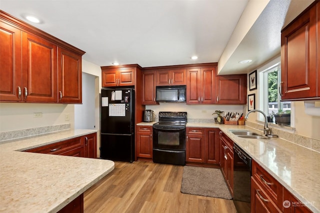 kitchen featuring light hardwood / wood-style flooring, black appliances, and sink