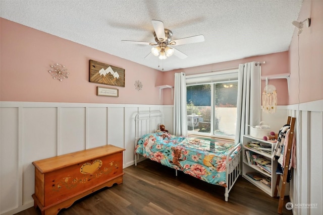 bedroom with ceiling fan, dark hardwood / wood-style flooring, and a textured ceiling