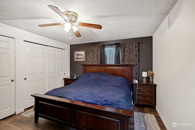 bedroom featuring ceiling fan, dark hardwood / wood-style flooring, a textured ceiling, and a closet