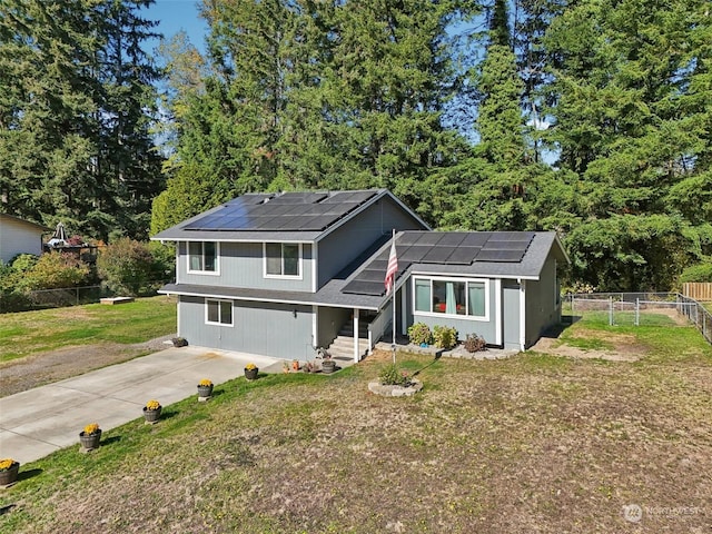 view of front of property with solar panels and a front lawn