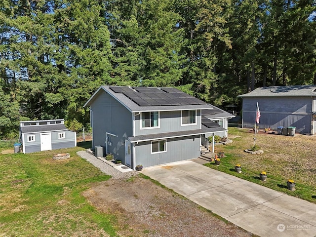 view of front of property with a front yard, solar panels, a storage shed, and central air condition unit