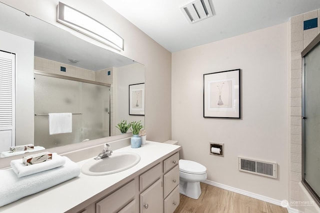 full bathroom with enclosed tub / shower combo, vanity, toilet, and hardwood / wood-style floors