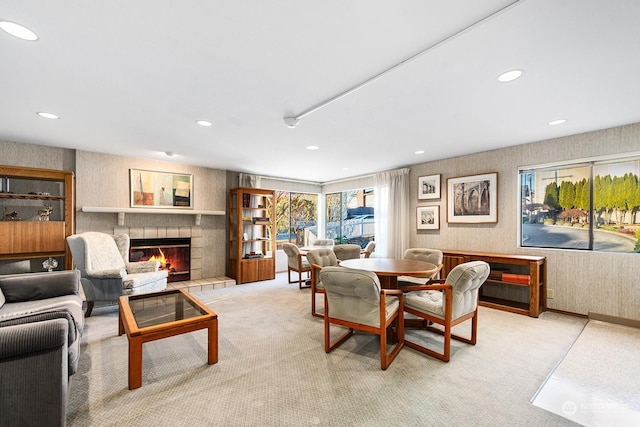 living room featuring a tiled fireplace and light carpet