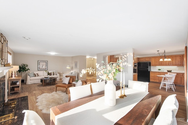 dining area featuring a notable chandelier, a high end fireplace, and light wood-type flooring