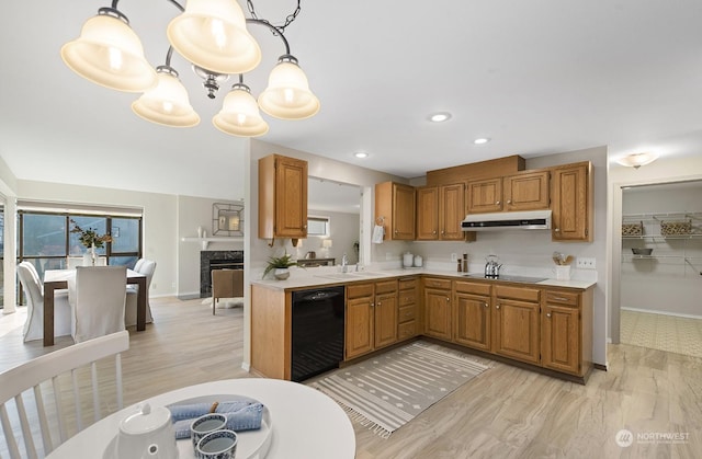 kitchen featuring pendant lighting, light wood-type flooring, and black appliances