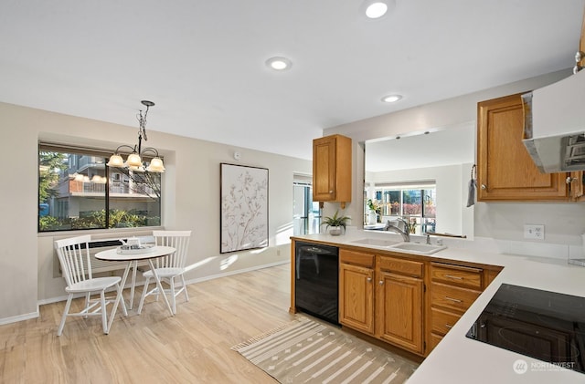 kitchen with sink, a chandelier, light hardwood / wood-style flooring, pendant lighting, and black appliances