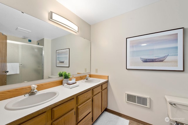 bathroom with a shower with door, vanity, and toilet