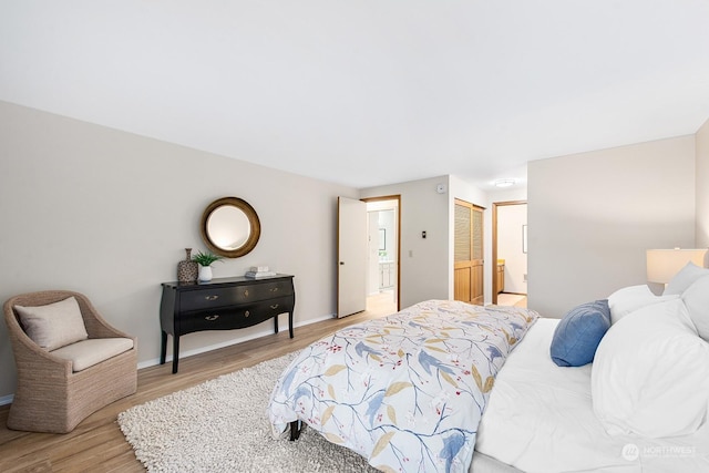 bedroom featuring connected bathroom, light hardwood / wood-style floors, and a closet