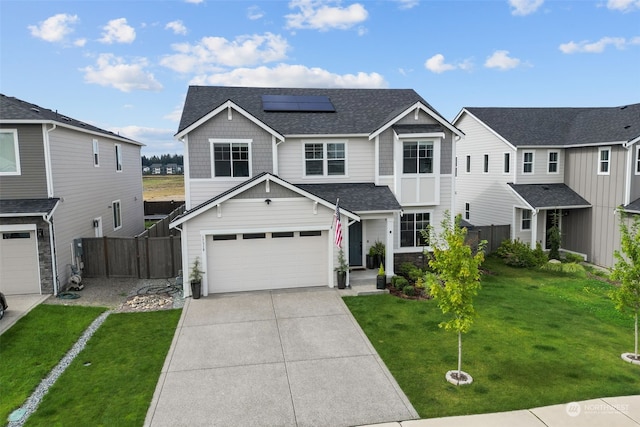 view of front property featuring solar panels, a garage, and a front lawn