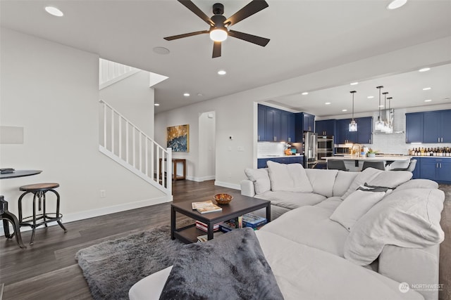 living room with ceiling fan and dark wood-type flooring