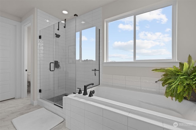 bathroom featuring plenty of natural light, separate shower and tub, and toilet