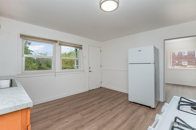 kitchen featuring white refrigerator, stove, and light hardwood / wood-style flooring