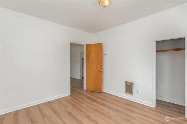 unfurnished bedroom with a closet and light wood-type flooring