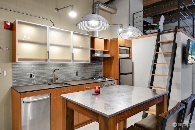 kitchen featuring sink, stainless steel appliances, range hood, pendant lighting, and decorative backsplash