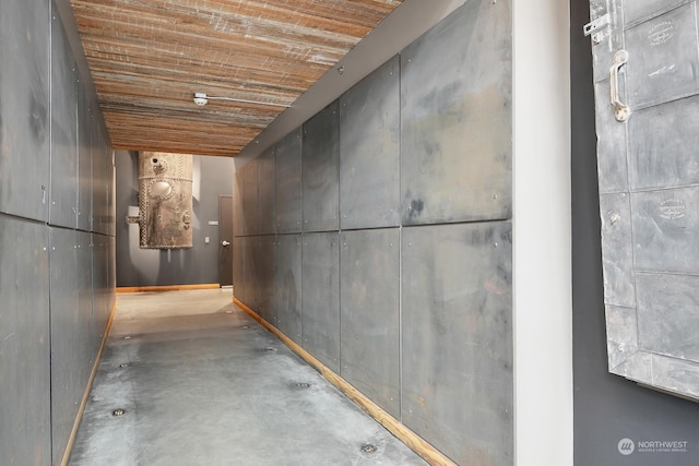 hall featuring wood ceiling and concrete floors