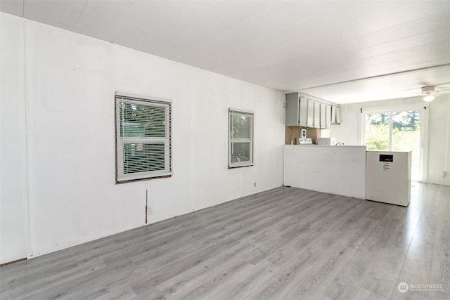 unfurnished living room featuring light wood-type flooring and ceiling fan