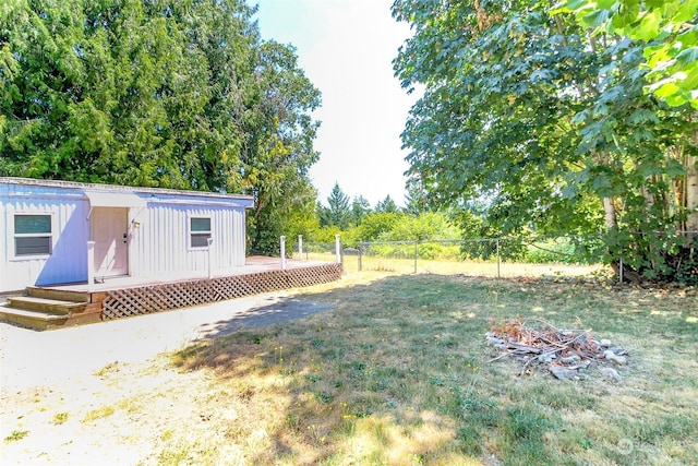 view of yard with a deck and an outdoor fire pit