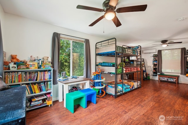 rec room with a wall mounted air conditioner, ceiling fan, and wood-type flooring