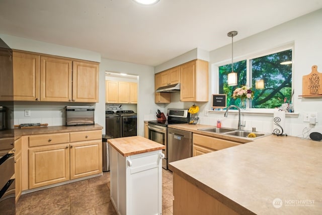 kitchen featuring wood counters, sink, washer and dryer, appliances with stainless steel finishes, and decorative light fixtures