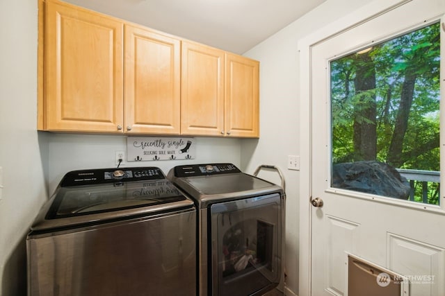 clothes washing area with cabinets, independent washer and dryer, and a wealth of natural light