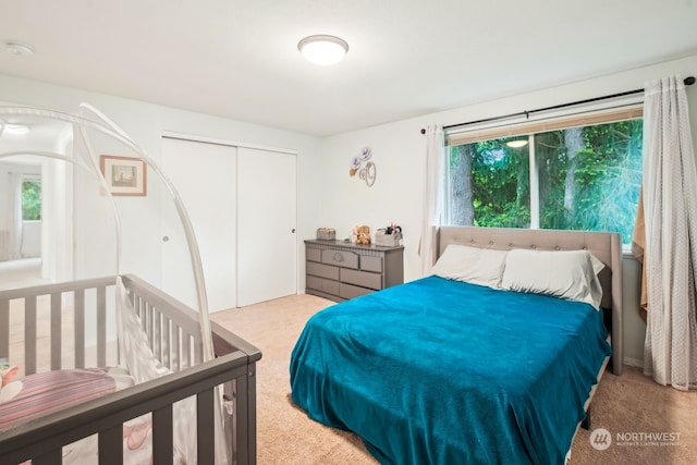 bedroom featuring light carpet and a closet