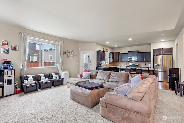 carpeted living room with sink