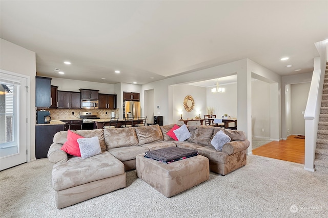 carpeted living room with a chandelier