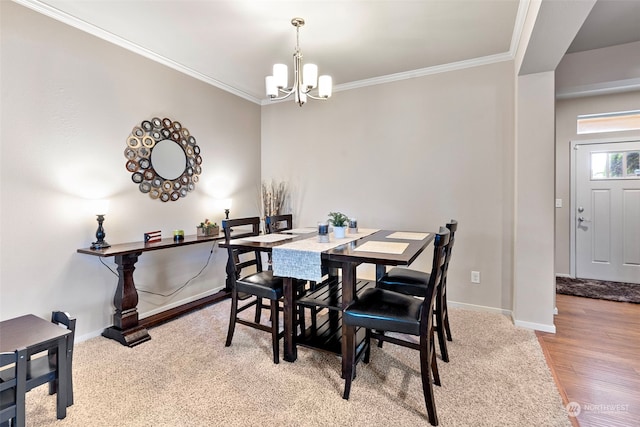 dining space with crown molding, wood-type flooring, and an inviting chandelier