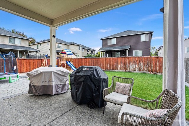 view of patio / terrace with a playground, a grill, and a trampoline