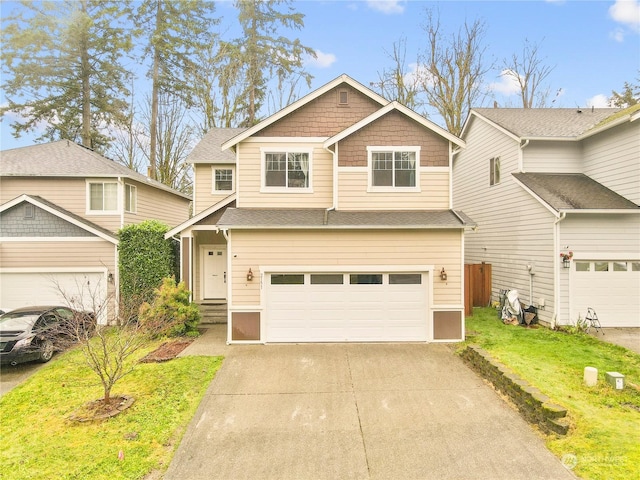 craftsman inspired home featuring a garage and a front lawn