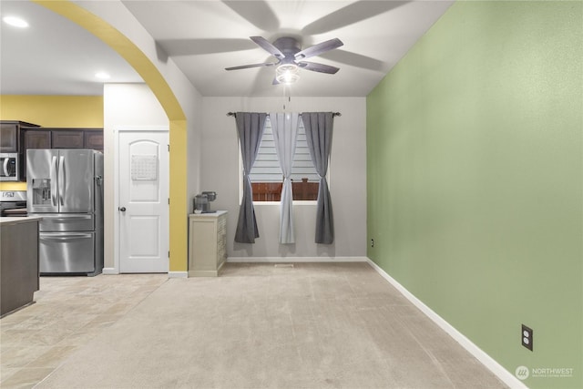 interior space featuring light carpet, dark brown cabinets, stainless steel appliances, and ceiling fan