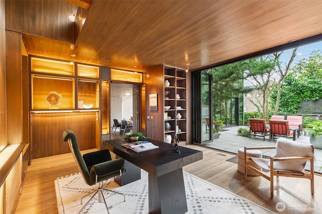 office area with built in shelves, light wood-type flooring, wooden ceiling, and floor to ceiling windows