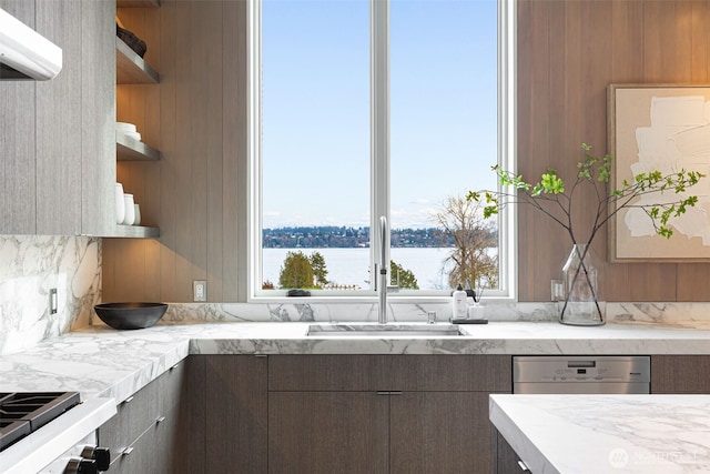 kitchen featuring modern cabinets, a water view, dark brown cabinets, open shelves, and a sink