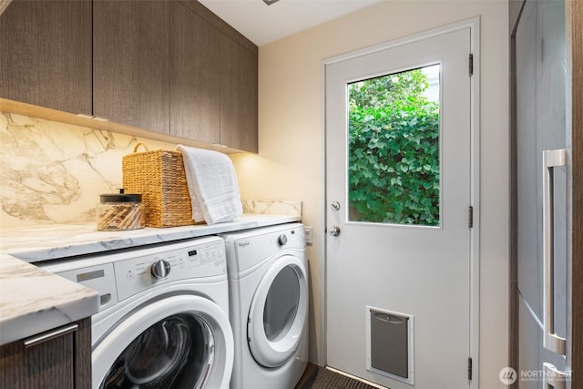 washroom with cabinet space and washer and dryer