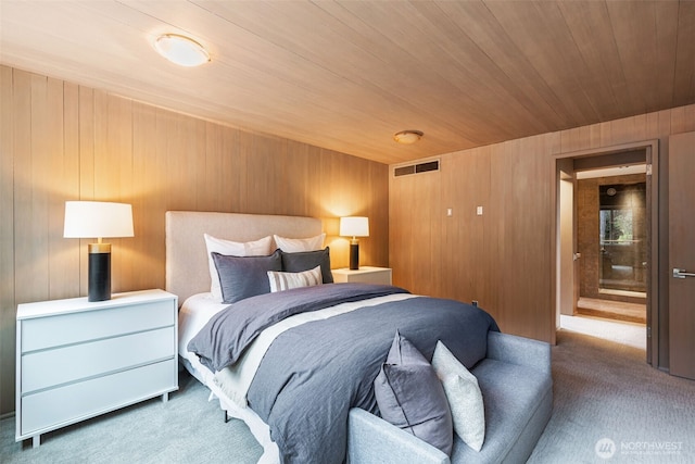 carpeted bedroom with wood ceiling, visible vents, and wooden walls