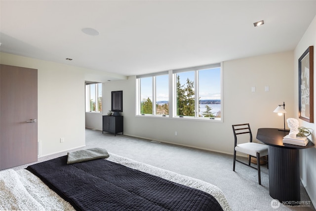 bedroom with baseboards, visible vents, and light colored carpet