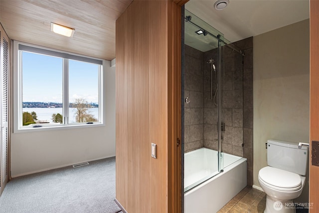 bathroom with baseboards, visible vents, toilet, enclosed tub / shower combo, and a water view