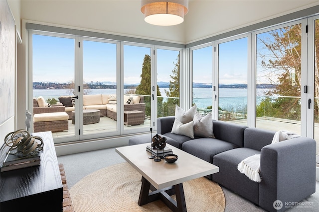 sunroom featuring a water view