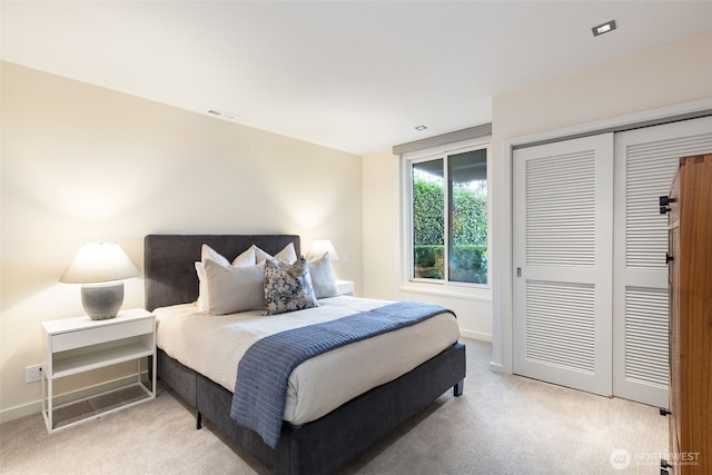 bedroom featuring light carpet, a closet, visible vents, and baseboards