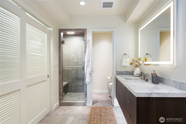 bathroom featuring visible vents, baseboards, toilet, vanity, and a shower stall