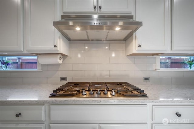 kitchen featuring backsplash, white cabinets, ventilation hood, and stainless steel gas cooktop