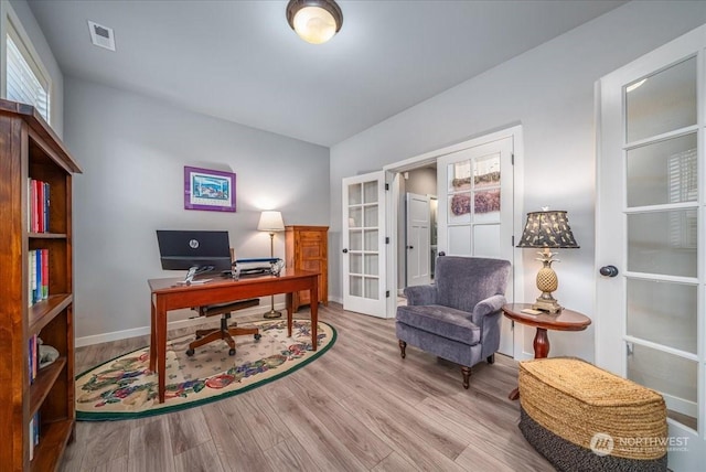 office area with light hardwood / wood-style flooring and french doors