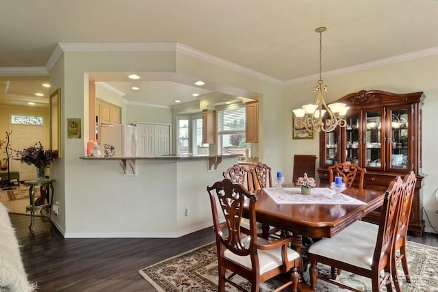 dining space featuring a chandelier, ornamental molding, and dark wood-type flooring