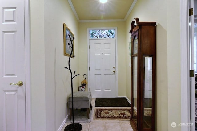 entryway with light tile patterned floors and crown molding