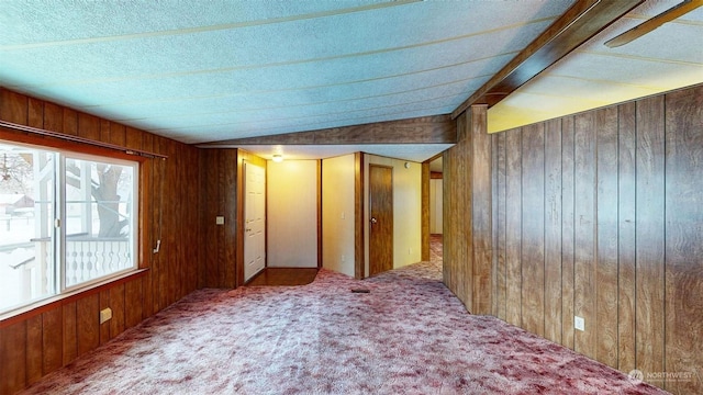 carpeted spare room with wood walls