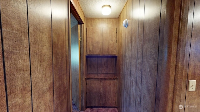 interior details featuring wood walls and a textured ceiling