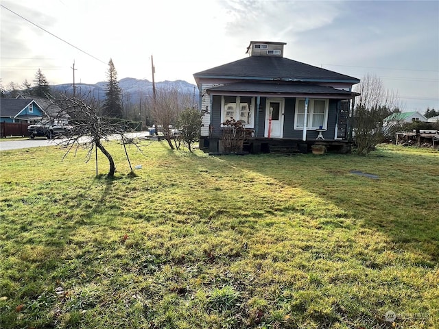 view of yard featuring a mountain view and covered porch