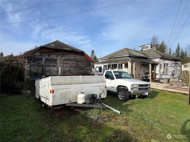 view of home's exterior featuring a lawn and an outbuilding