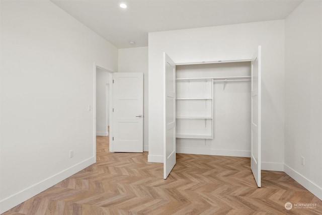 unfurnished bedroom featuring a closet and light parquet floors