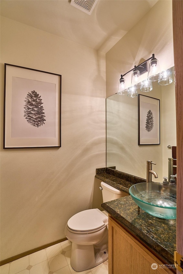 bathroom with tile patterned flooring, vanity, and toilet